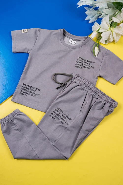طقم ولادي قطعتين لون رصاصي تيشيرت بكتابات من الأمام مع بنطلون طويل برباط في الوسط و زم في الأسفل و جيوب من الجانبين