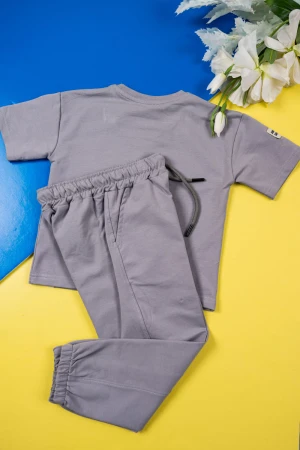 طقم ولادي قطعتين لون رصاصي تيشيرت بكتابات من الأمام مع بنطلون طويل برباط في الوسط و زم في الأسفل و جيوب من الجانبين