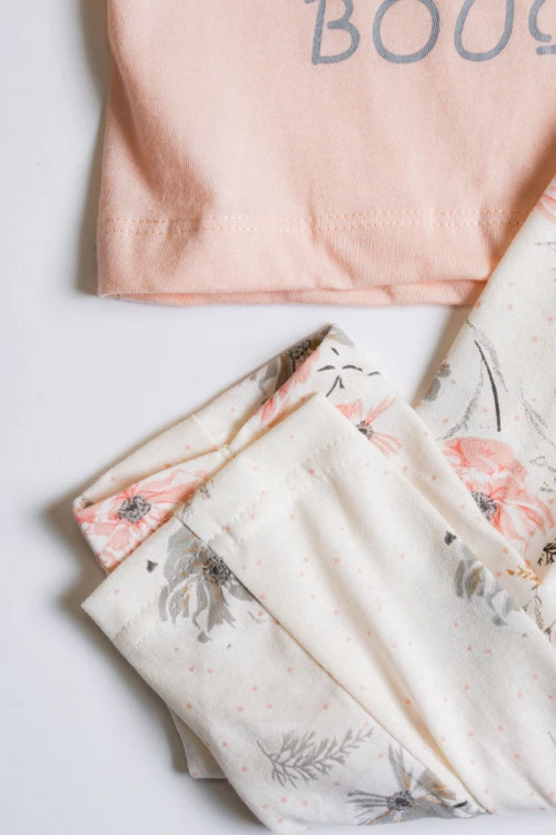 بيجاما بناتي  قطعتين تيشيرت لون خربزي مزين برسومات و كتابات من الأمام مع بنطلون بيج فاتح مشجر