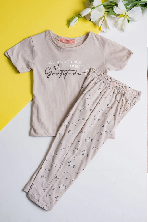 بيجاما بناتي قطعتين لون بيج مزين بكتابات و رسومات من الأمام مع بنطلون مشجر