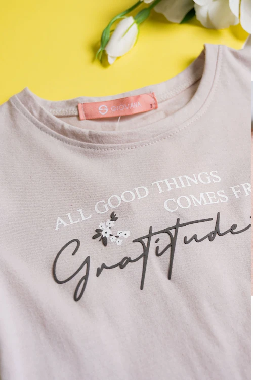 بيجاما بناتي قطعتين لون بيج مزين بكتابات و رسومات من الأمام مع بنطلون مشجر