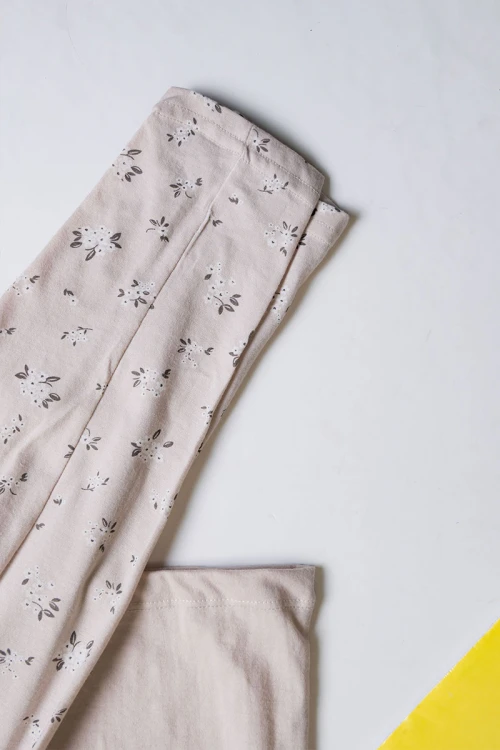 بيجاما بناتي قطعتين لون بيج مزين بكتابات و رسومات من الأمام مع بنطلون مشجر