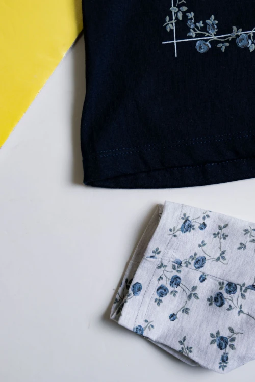 بيجاما بناتي قطعتين تيشيرت لون كحلي مزين برسومات و كتابات من الأمام مع بنطلون رمادي فاتح مشجر