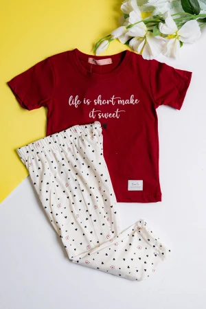 بيجاما بناتي قطعتين تيشيرت لون عودي مزين بكتابات و رسومات من الأمام مع بنطلون اوف وايت بقلوب ملونة