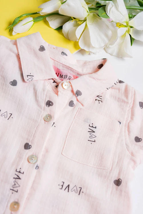 بيجاما بناتي قطعتين لون خربزي مزين برسومات و كتابات تيشيرت بياقة مطوية و أزرار من الأمام مع بنطلون طويل برباط في الخصر