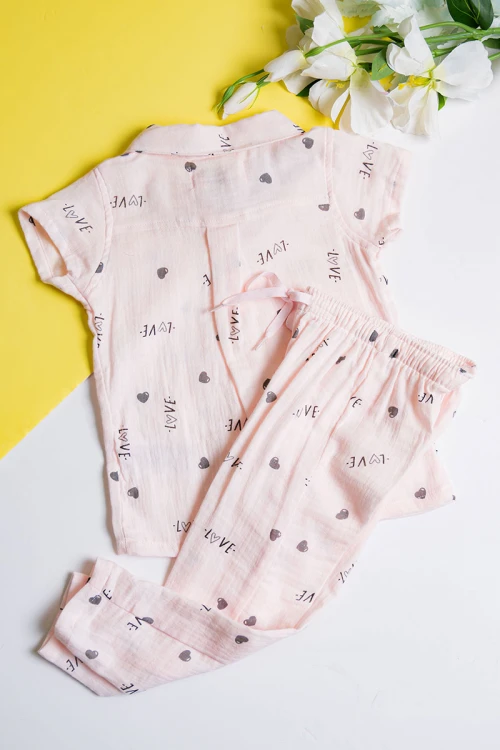 بيجاما بناتي قطعتين لون خربزي مزين برسومات و كتابات تيشيرت بياقة مطوية و أزرار من الأمام مع بنطلون طويل برباط في الخصر