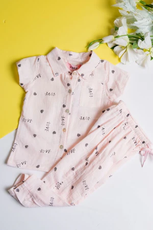 بيجاما بناتي قطعتين لون خربزي مزين برسومات و كتابات تيشيرت بياقة مطوية و أزرار من الأمام مع بنطلون طويل برباط في الخصر  