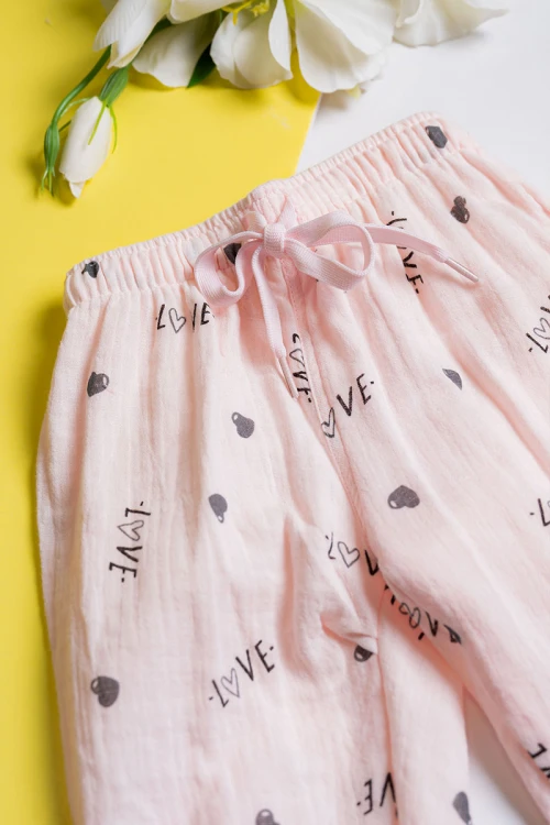 بيجاما بناتي قطعتين لون خربزي مزين برسومات و كتابات تيشيرت بياقة مطوية و أزرار من الأمام مع بنطلون طويل برباط في الخصر