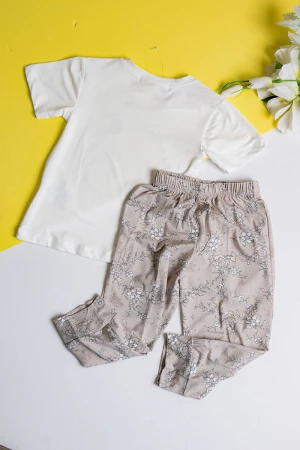 بيجاما بناتي قطعتين تيشيرت لون أبيض مزين برسومات و كتابات من الأمام مع بنطلون طويل لون بيج مشجر 