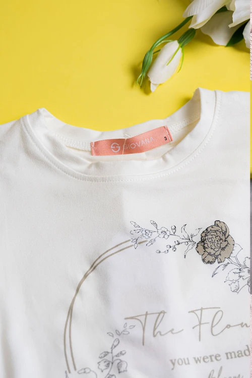 بيجاما بناتي قطعتين تيشيرت لون أبيض مزين برسومات و كتابات من الأمام مع بنطلون طويل لون بيج مشجر