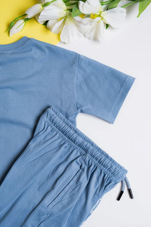 طقم ولادي قطعتين لون سماوي تيشيرت مزين بكتابات من الأمام مع بنطلون طويل بجيوب و رباط في الخصر