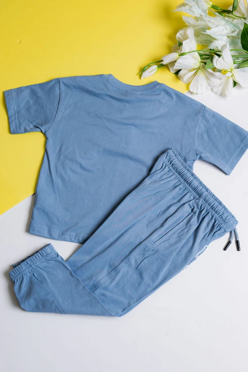 طقم ولادي قطعتين لون سماوي تيشيرت مزين بكتابات من الأمام مع بنطلون طويل بجيوب و رباط في الخصر