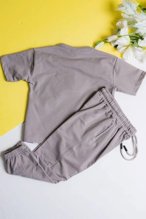 طقم ولادي قطعتين لون رمادي تيشيرت مزين بكتابات من الأمام مع بنطلون طويل بجيوب و رباط في الخصر 