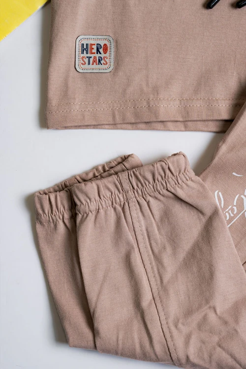 طقم ولادي قطعتين لون بيج تيشيرت مزين بكتابات و رسومات من الأمام مع بنطلون طويل بجيوب و رباط في الخصر