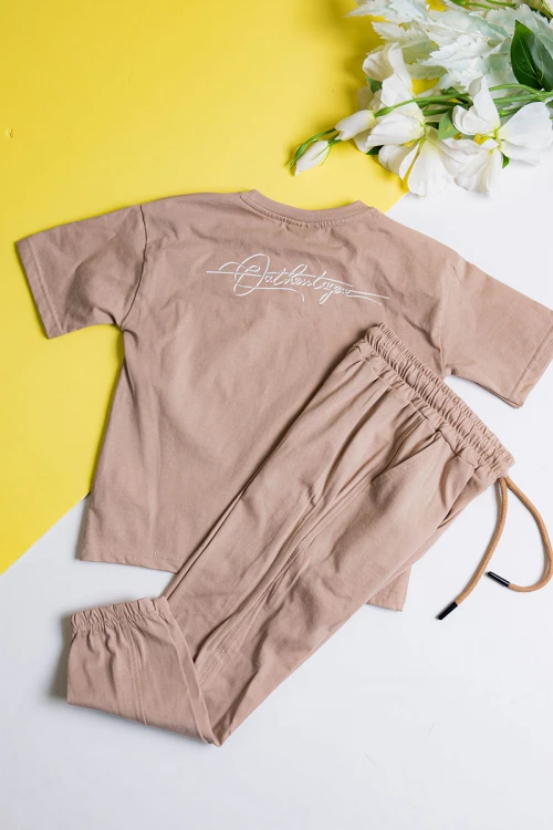 طقم ولادي قطعتين لون بيج تيشيرت مزين بكتابات و رسومات من الأمام مع بنطلون طويل بجيوب و رباط في الخصر