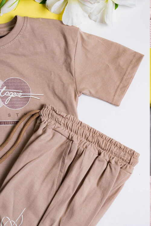 طقم ولادي قطعتين لون بيج تيشيرت مزين بكتابات و رسومات من الأمام مع بنطلون طويل بجيوب و رباط في الخصر