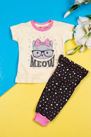 بيجاما بناتي قطعتين تيشيرت لون بيج مزين برسومات و كتابات من الأمام مع بنطلون لون أسود مزين بقلوب ملونة و بزم في الأسفل 