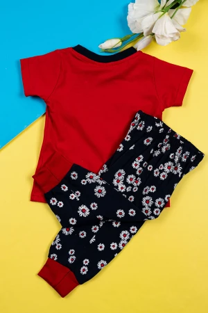 بيجاما بناتي قطعتين تيشيرت لون أحمر مزين بكتابات من الأمام مع بنطلون لون أسود مزين بزهور ملونة و بزم في الأسفل 