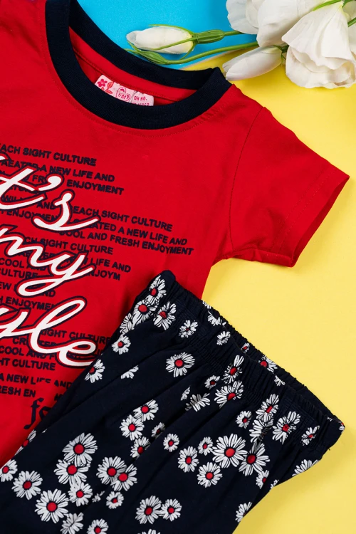 بيجاما بناتي قطعتين تيشيرت لون أحمر مزين بكتابات من الأمام مع بنطلون لون أسود مزين بزهور ملونة و بزم في الأسفل