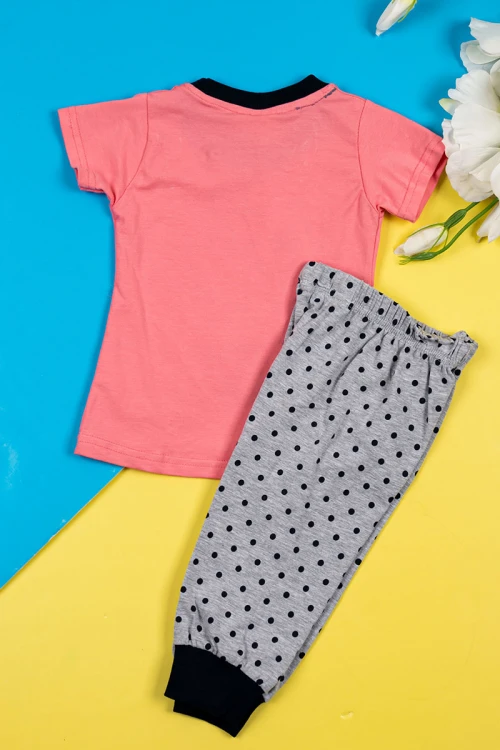 بيجاما بناتي قطعتين تيشيرت لون وردي مزين برسومات و كتابات من الأمام مع بنطلون لون رمادي منقط باللون الأسود و بزم في الأسفل