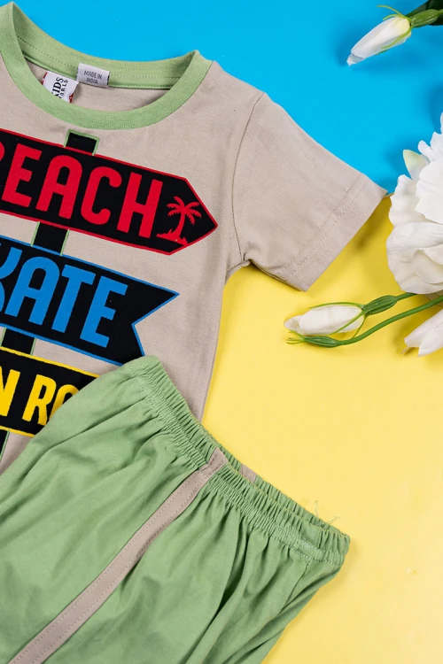 بيجاما ولادي قطعتين تيشيرت لون بيج غامق مزين برسومات و كتابات من الأمام مع شورت لون تفاحي