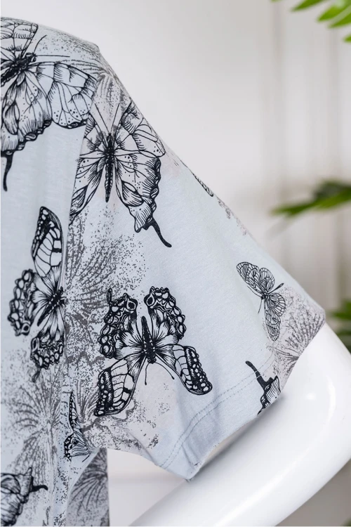 قميص نسائي جامبو طويل لون رمادي مزين برسومات ياقة دائرية بأزرار من الأمام و بأكمام قصيرة