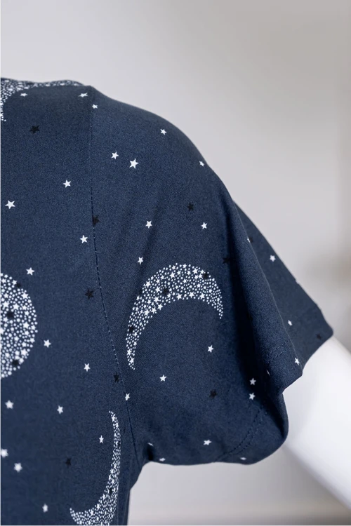 قميص نسائي طويل لون كحلي مزين برسومات ياقة دائرية بأزرار من الأمام و بأكمام قصيرة