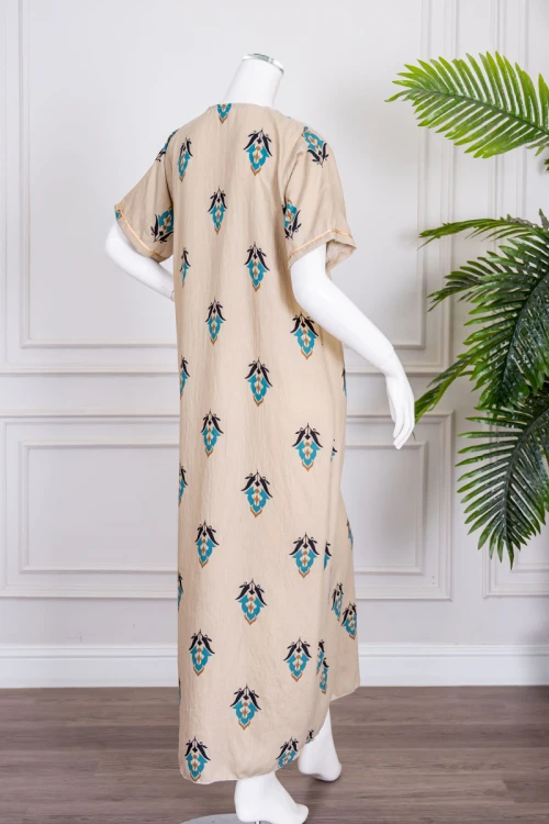 جلابية نسائية لون بيج مزينة بزخارف ملونة ياقة بقصة سبعة بكلفة مطرزة باللون الذهبي من الياقة و بأكمام قصيرة