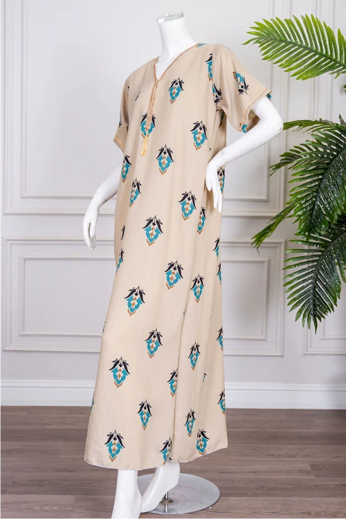 جلابية نسائية لون بيج مزينة بزخارف ملونة ياقة بقصة سبعة بكلفة مطرزة باللون الذهبي من الياقة و بأكمام قصيرة