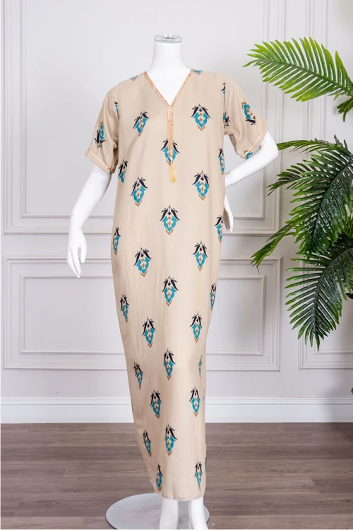 جلابية نسائية لون بيج مزينة بزخارف ملونة ياقة بقصة سبعة بكلفة مطرزة باللون الذهبي من الياقة و بأكمام قصيرة