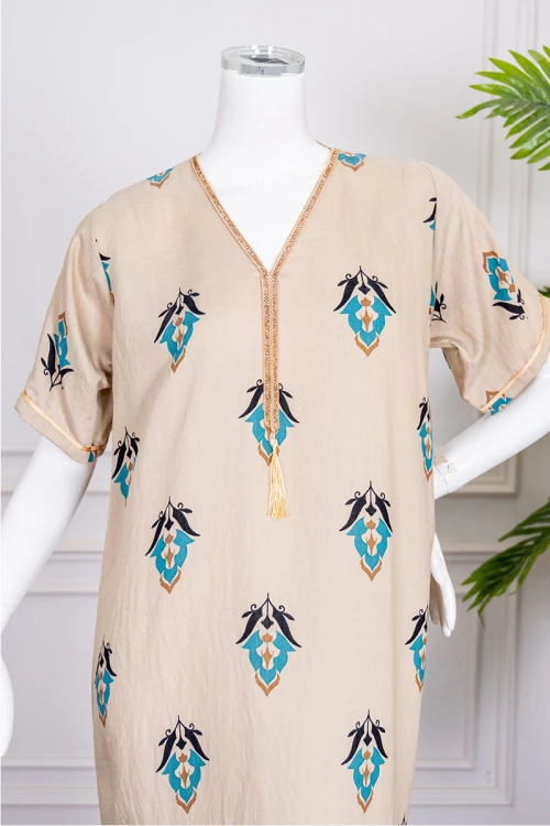 جلابية نسائية لون بيج مزينة بزخارف ملونة ياقة بقصة سبعة بكلفة مطرزة باللون الذهبي من الياقة و بأكمام قصيرة