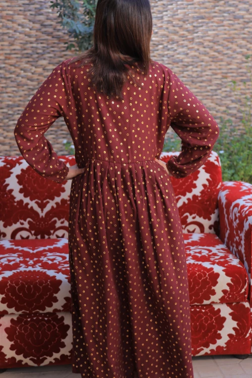 فستان تراثي نسائي أنيق قطعتين لون عودي بتطريز وطبعات لامعة باللون الذهبي مع عباية شفافة باللون الأسود